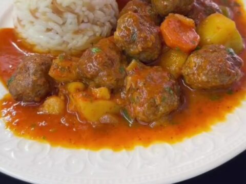 Baked Turkish meatballs and potato wedges in a red tomato sauce, garnished with parsley