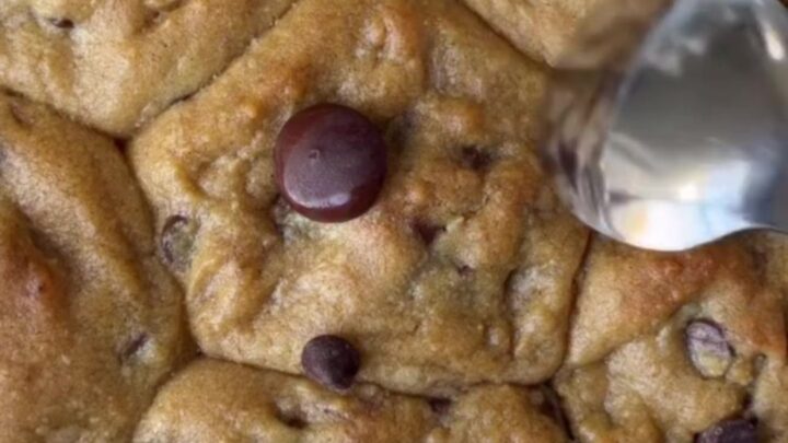 Crispy edge chocolate chip cookies with melted chocolate and flaky sea salt on a cooling rack