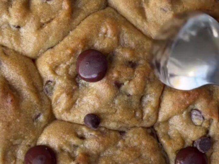Crispy edge chocolate chip cookies with melted chocolate and flaky sea salt on a cooling rack