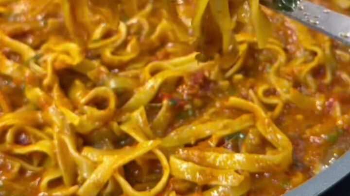 One-pan tagliatelle with tomato, zucchini, and melted mozzarella in a skillet
