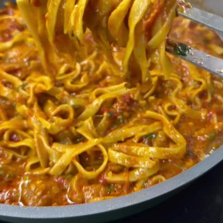One-pan tagliatelle with tomato, zucchini, and melted mozzarella in a skillet