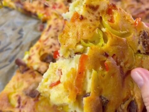 Thick sheet-pan pizza with melted mozzarella, sucuk slices, and sweet peppers on a golden crust