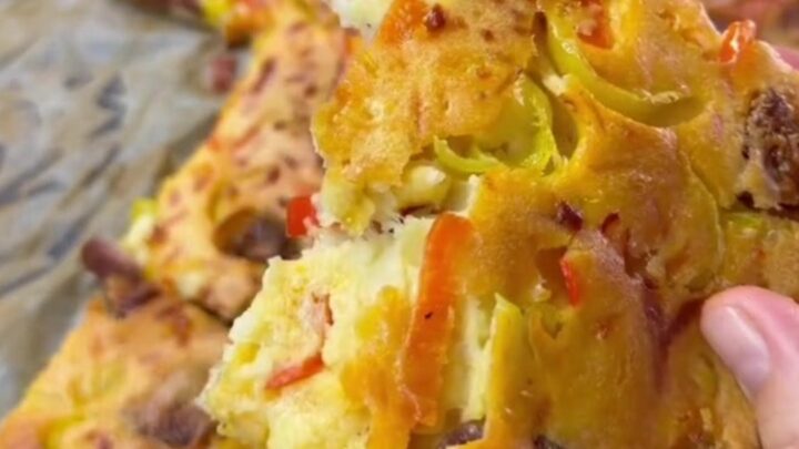 Thick sheet-pan pizza with melted mozzarella, sucuk slices, and sweet peppers on a golden crust