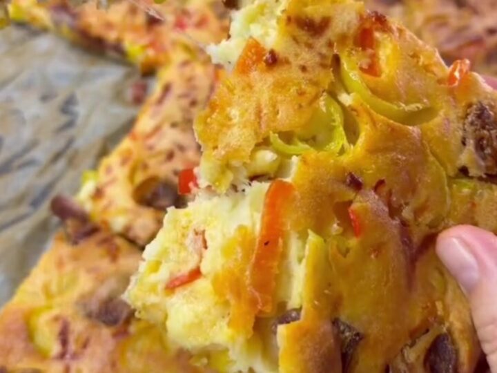 Thick sheet-pan pizza with melted mozzarella, sucuk slices, and sweet peppers on a golden crust