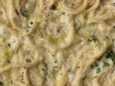 Twirled spaghetti coated in creamy lemon garlic sauce, topped with parsley and black pepper