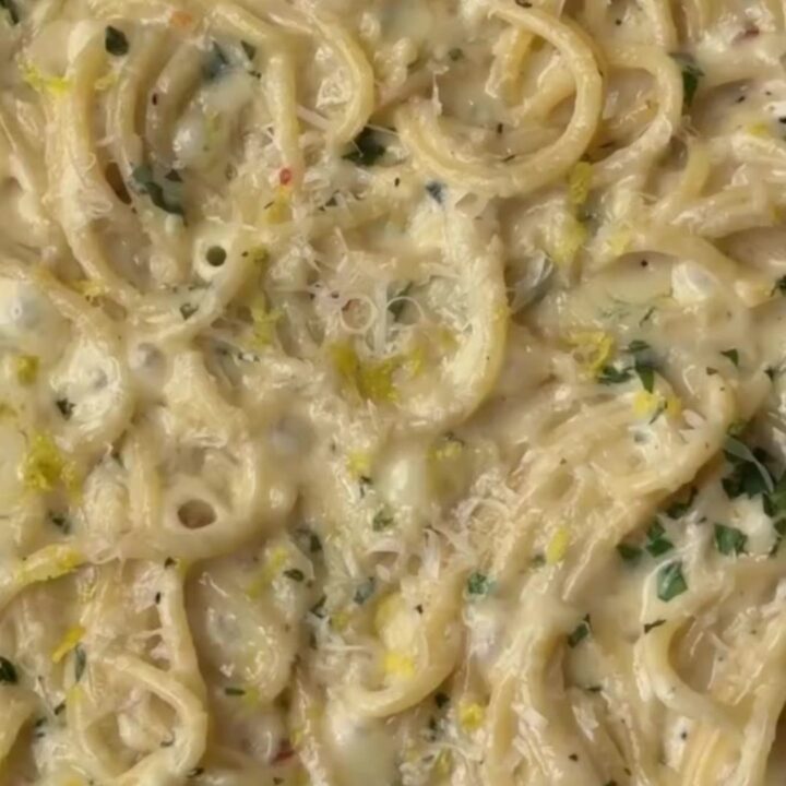 Twirled spaghetti coated in creamy lemon garlic sauce, topped with parsley and black pepper