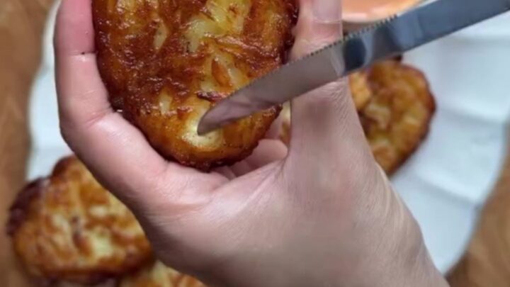 Golden crispy garlic parmesan hashbrowns stacked on a plate, with a crackly crust and fluffy interior.