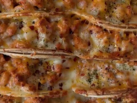 Golden baked chicken tacos on a sheet pan with melted cheese and crispy shells