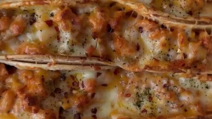 Golden baked chicken tacos on a sheet pan with melted cheese and crispy shells