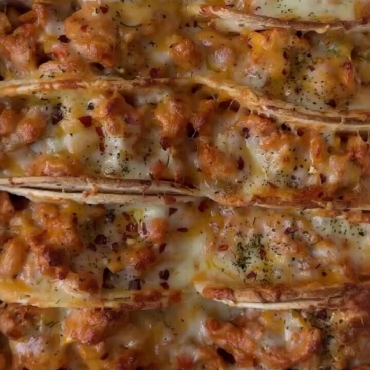 Golden baked chicken tacos on a sheet pan with melted cheese and crispy shells