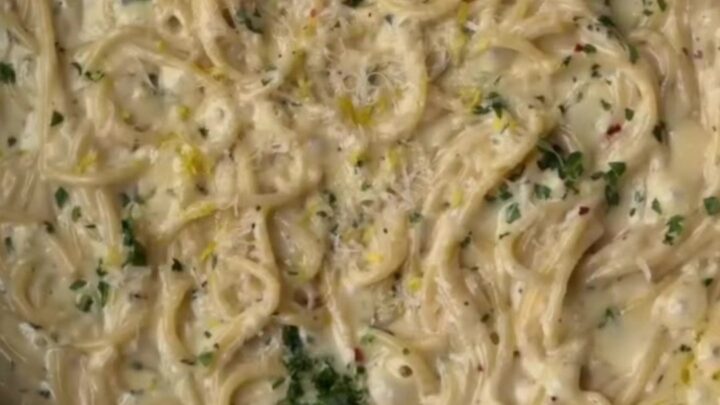 Creamy lemon garlic spaghetti twirled on a fork, coated in silky sauce with parsley and black pepper