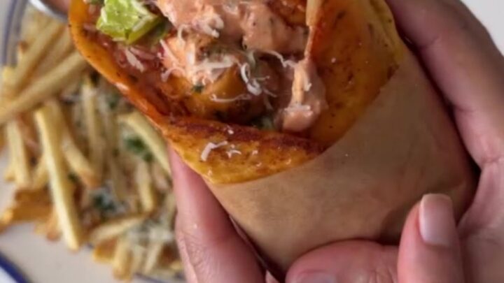 A crispy garlic parmesan chicken wrap cut diagonally, showing molten mozzarella and chicken cubes