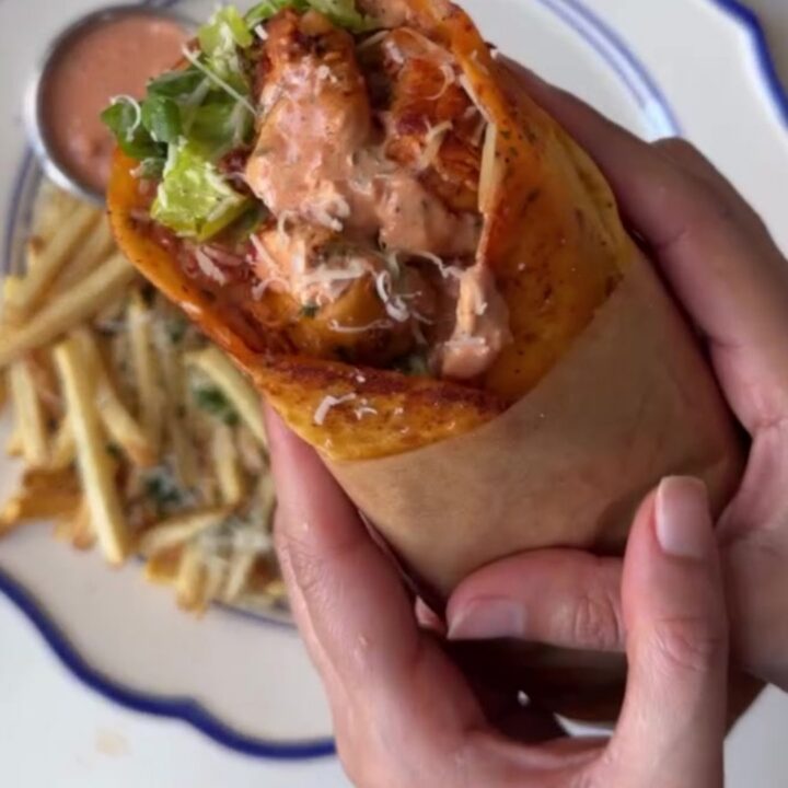 A crispy garlic parmesan chicken wrap cut diagonally, showing molten mozzarella and chicken cubes