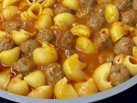One-pot meatball pasta with penne, mini beef meatballs, and melted mozzarella in a rich tomato sauce, garnished with parsley.