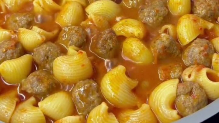 One-pot meatball pasta with penne, mini beef meatballs, and melted mozzarella in a rich tomato sauce, garnished with parsley.