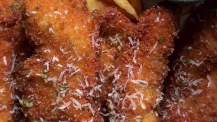 Crispy garlic parmesan chicken tenders with a creamy sweet chili dip in a small bowl, golden and crunchy.