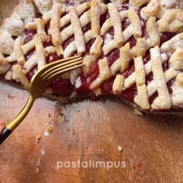 Slice of strawberry chocolate tart with lattice top and powdered sugar