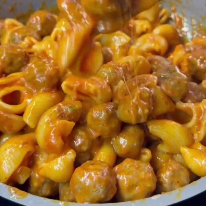 One-pan cheesy meatball shell pasta in a skillet with melted mozzarella and parsley