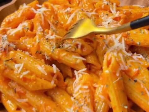 Creamy roasted tomato garlic penne pasta with melted cheese and fresh basil