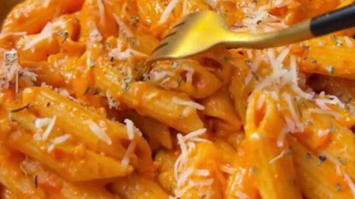 Creamy roasted tomato garlic penne pasta with melted cheese and fresh basil