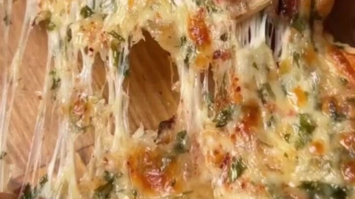 Golden mini pide with melted cheese stretching between two pieces