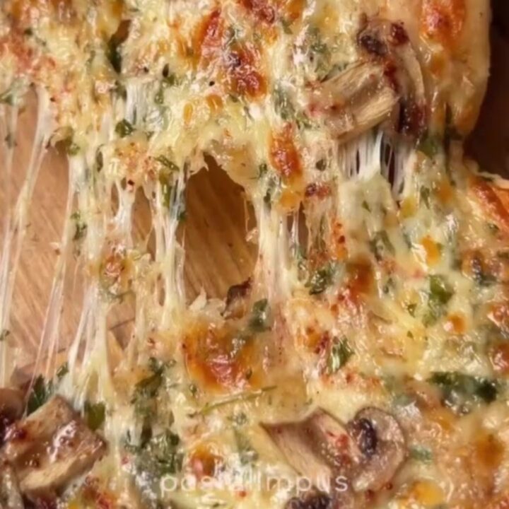 Golden mini pide with melted cheese stretching between two pieces