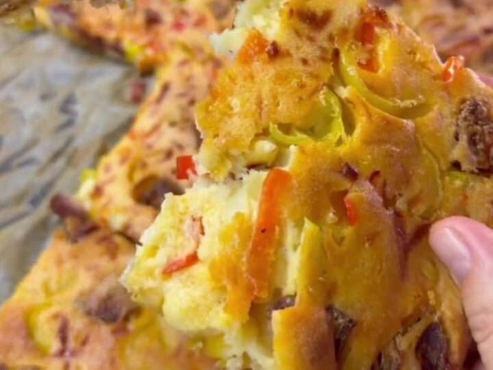 Golden sheet pan crepe pizza topped with melted cheese, sucuk slices, peppers, and corn