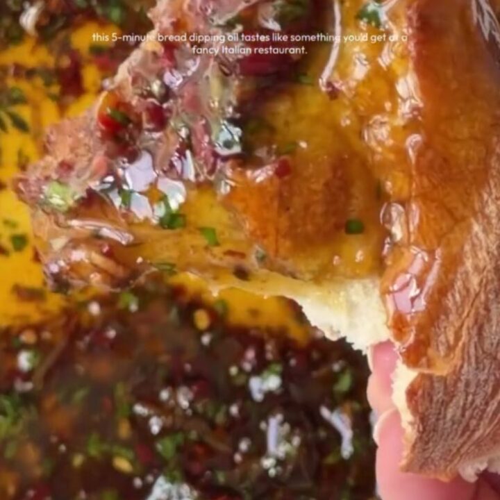 A ceramic plate with golden olive oil, balsamic swirls, sun-dried tomatoes, and Parmesan, surrounded by torn sourdough bread.