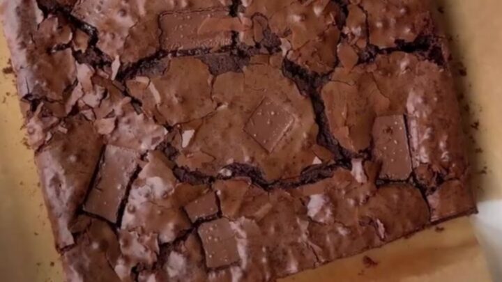 A stack of fudgy brownies with a shiny, crackly top and gooey chocolate center.