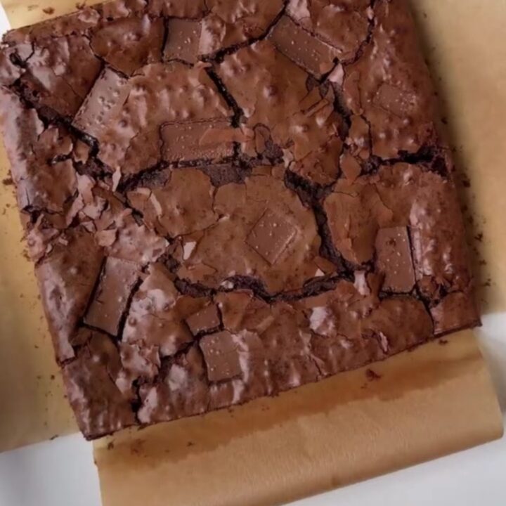 A stack of fudgy brownies with a shiny, crackly top and gooey chocolate center.