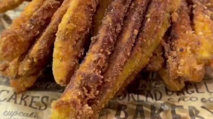 Golden crispy eggplant fries piled on a plate with a bowl of garlic yogurt dip