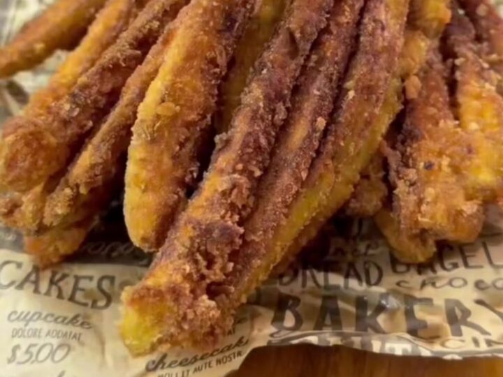 Golden crispy eggplant fries piled on a plate with a bowl of garlic yogurt dip