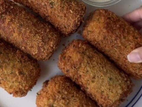 Crispy golden bread rolls stacked on a plate with a bowl of ranch dressing