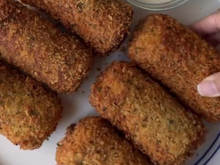 Crispy golden bread rolls stacked on a plate with a bowl of ranch dressing
