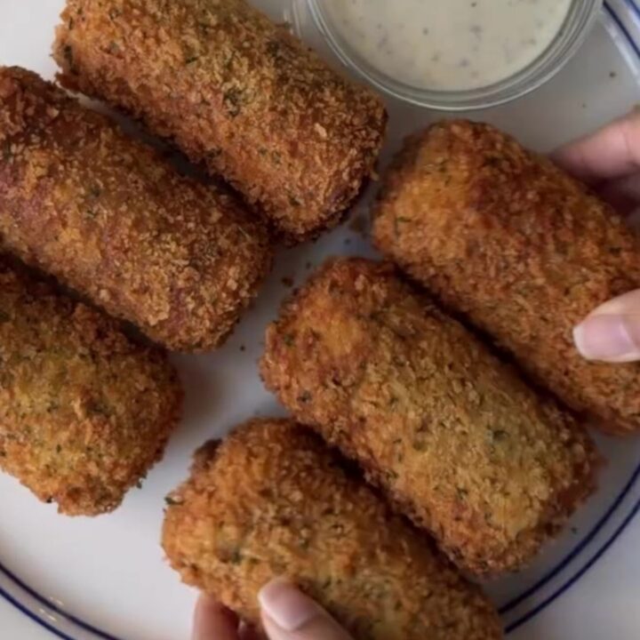 Crispy golden bread rolls stacked on a plate with a bowl of ranch dressing