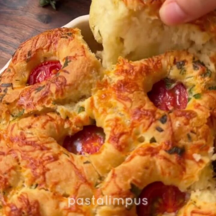 Golden pull-apart bread rolls with melted cheese stretching between them.