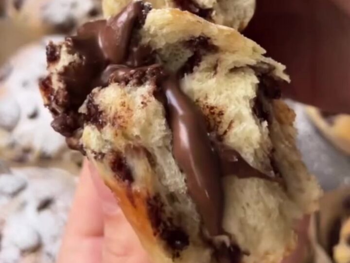 Golden brioche buns with chocolate chips and a molten chocolate hazelnut center, dusted with powdered sugar.