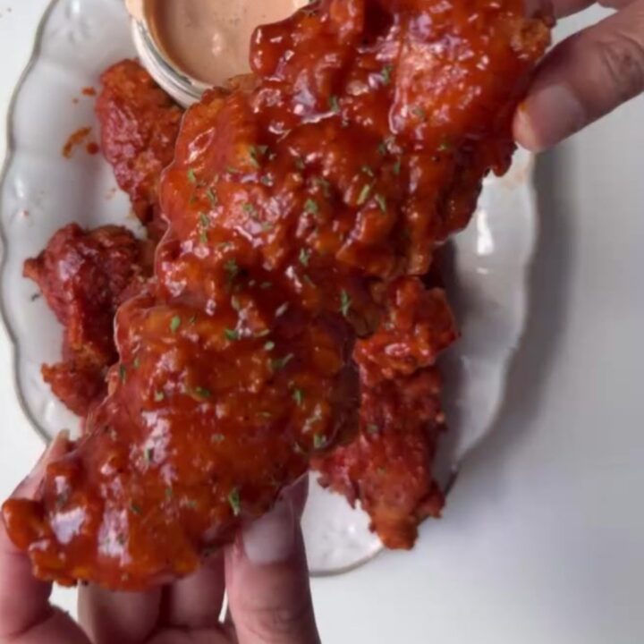 Crispy honey BBQ chicken tenders on a plate with creamy dip