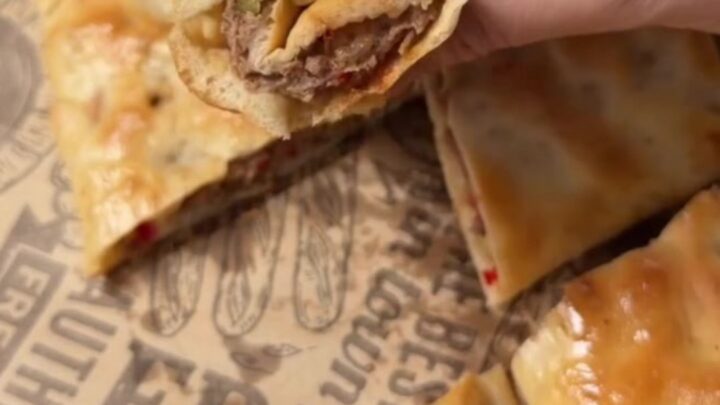 Golden Turkish pide with spiced beef, torn open to show juicy filling