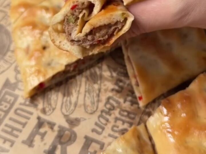 Golden Turkish pide with spiced beef, torn open to show juicy filling