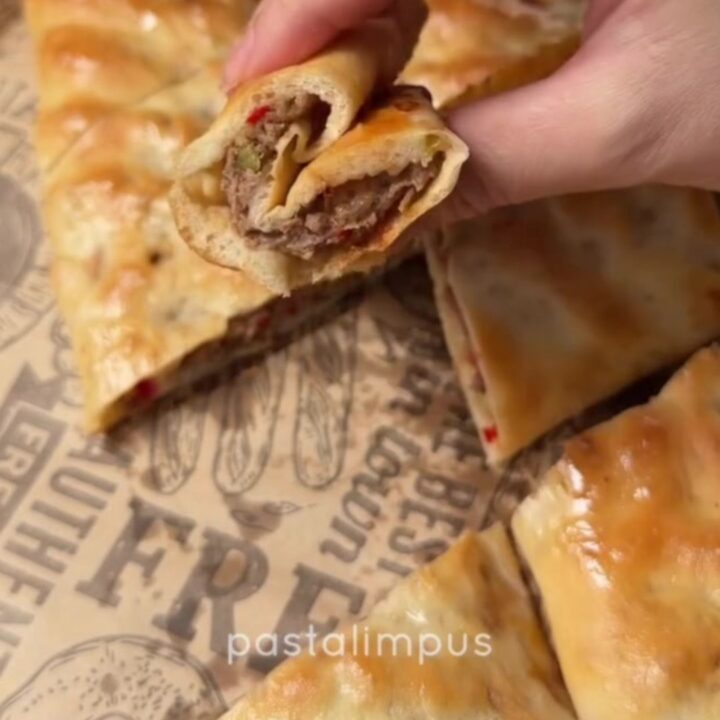 Golden Turkish pide with spiced beef, torn open to show juicy filling