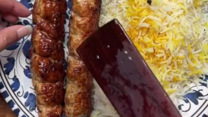 Juicy charred chicken kebabs over saffron rice with cucumber-tomato salad