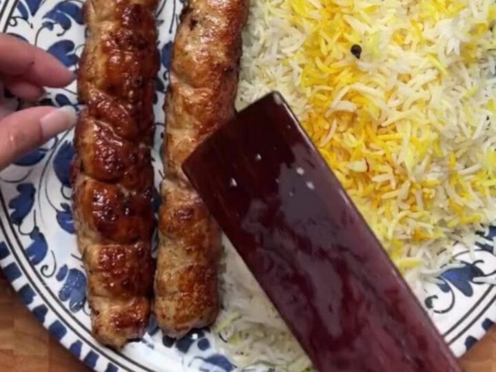 Juicy charred chicken kebabs over saffron rice with cucumber-tomato salad