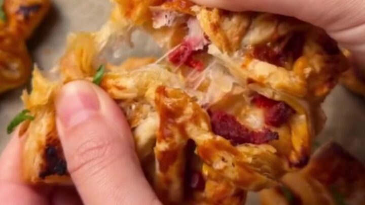 Golden puff pastry pizza flowers with sucuk and peppers on a baking sheet