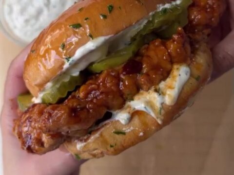 Crispy fried chicken sandwich with honey chipotle glaze dripping, on a toasted brioche bun with dill ranch and pickles