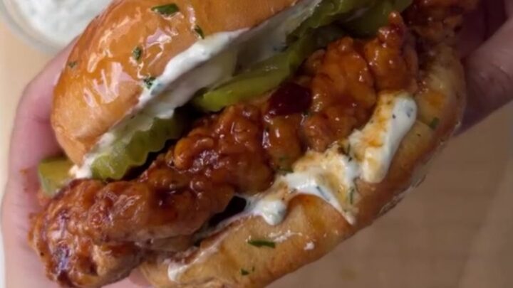 Crispy fried chicken sandwich with honey chipotle glaze dripping, on a toasted brioche bun with dill ranch and pickles