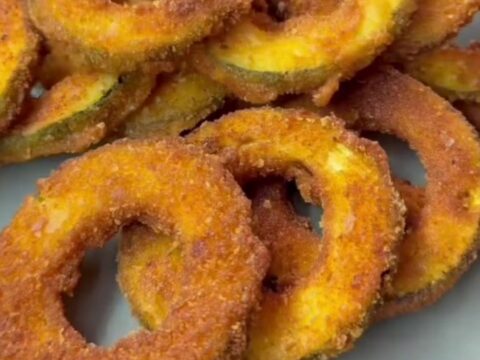 Crispy golden zucchini rings with a crunchy breadcrumb crust, served with a bowl of creamy garlic yogurt for dipping.