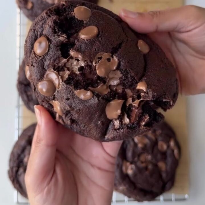 Pulling apart a warm, thick chocolate cookie with molten chocolate pools
