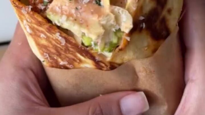Crispy chicken Caesar wrap sliced diagonally, showing crunchy chicken, romaine, and parmesan.