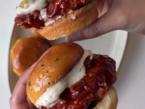 Hot honey chicken slider with crispy chicken, slaw, and pickles on a brioche bun